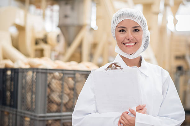 Woman working at a bread factory doing quality control and wearing a uniform